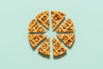 Apple pie cut into slices, isolated on green background. flat lay with homemade apple pie slices.