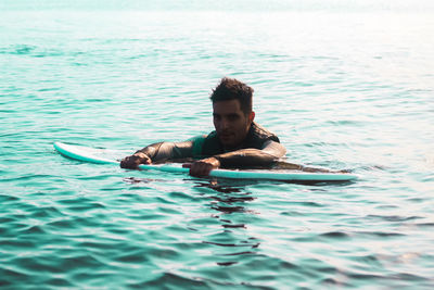 Young man on water, surfing