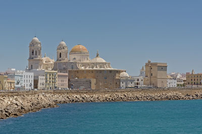 View of buildings against clear blue sky