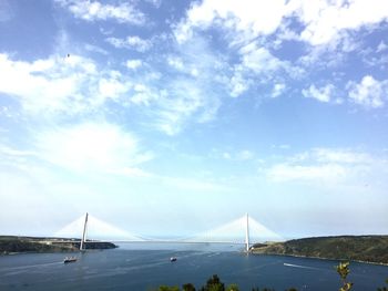 Suspension bridge over sea against sky