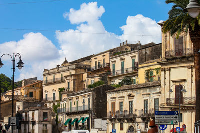 Low angle view of buildings against cloudy sky