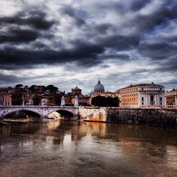 River by cityscape against sky