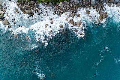 High angle view of waves splashing on rocks