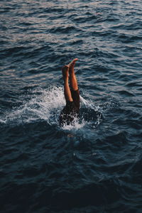 High angle view of person with feet up swimming in sea