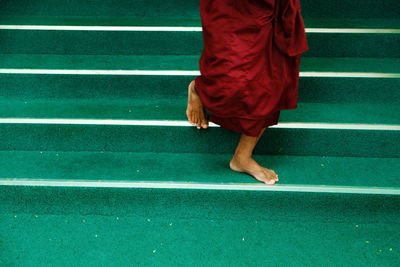 Low section of barefoot buddhist monk walking down on stairs. mandalay. amarapura. myanmar, burma
