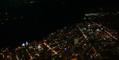 Illuminated city against sky at night