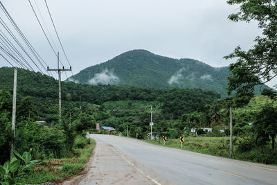 Road by mountains against sky