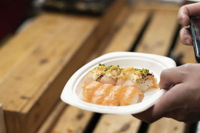 Midsection of person holding food on table