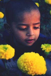Close of boy looking at yellow flowers