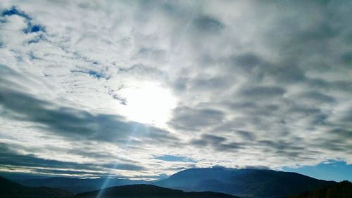 Scenic view of mountains against cloudy sky