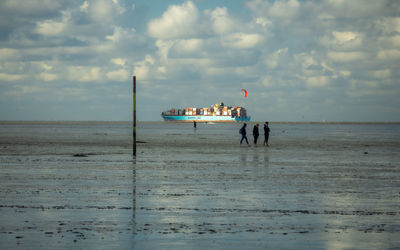 People on beach against sky