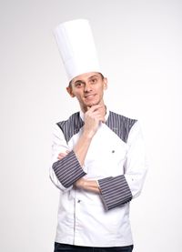 Portrait of young man standing against white background