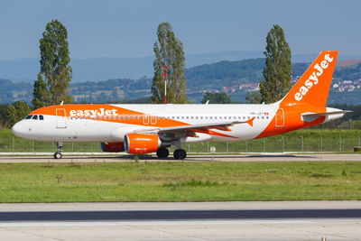 Airplane on airport runway against sky