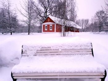 House on snow covered field by building