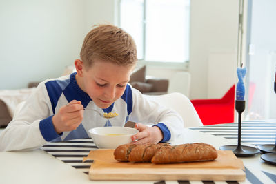Boy eating food on table