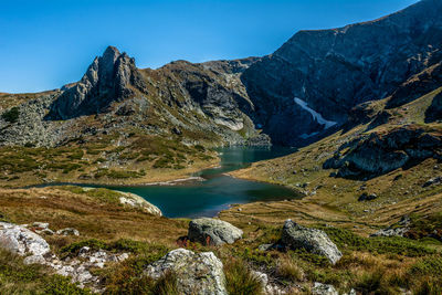 Scenic view of lake and mountains against blue sky