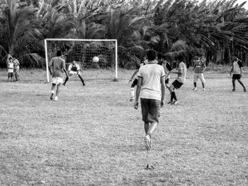 Group of people playing soccer on field