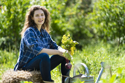 Portrait of smiling young woman sitting outdoors