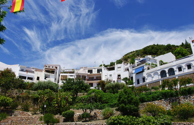 Buildings and trees against blue sky