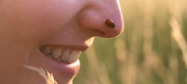 Young woman playing with a cute ladybug in the nature at sunset. back to the nature concept. 