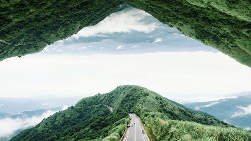 Scenic view of road passing through mountain against sky