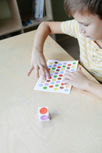 Child playing diy dot game for fingers. useful game for development of childs fingers