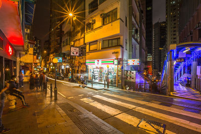 Illuminated city street and buildings at night