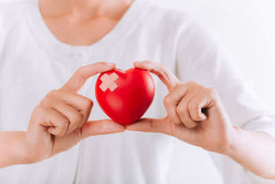 Midsection of woman holding red heart