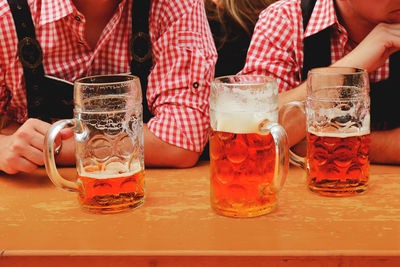 Midsection of woman with drink on table