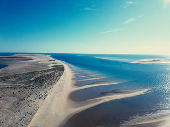 Scenic view of beach against clear blue sky