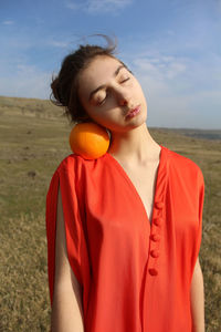 Midsection of woman standing by tree on field against sky