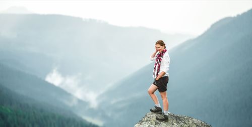 Full length of woman standing against mountain