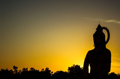 Low angle view of silhouette statue against sky during sunset