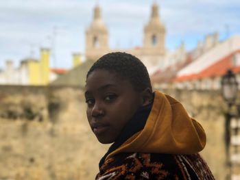 Portrait of young woman against buildings