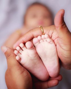 Cropped hands of person holding baby feet