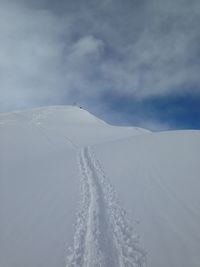 Scenic view of snow covered mountain against cloudy sky