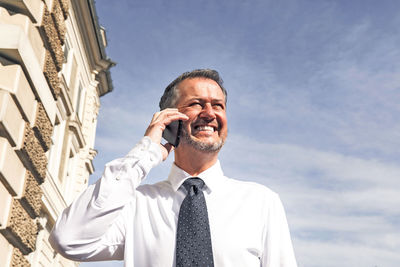 Successful smiling business man, professor, in university park, academic building