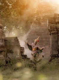 Thai woman in antique place, outdoor, performing traditional thai dance
