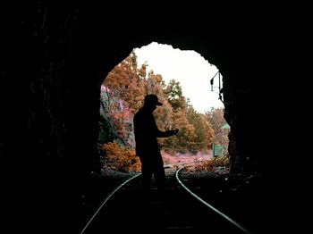 Silhouette of man standing in tunnel