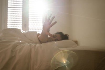 Portrait of woman lying on bed at home