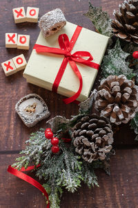 Christmas festive gift box and sweets with seasons decorations on wooden background