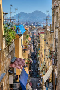 Small alleyway in the old town of naples with mount vesuvius in the back