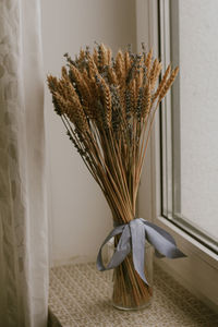 Close-up of vase on table against window at home