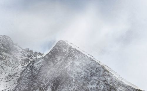 Low angle view of snowcapped mountain against sky