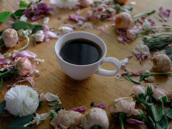 Close-up of coffee cup and flowers on table