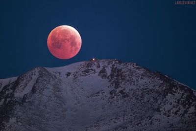 Scenic view of snowcapped mountain against sky at night