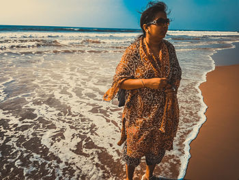 Woman standing on beach against sea