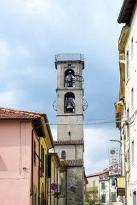 Low angle view of clock tower amidst buildings in city