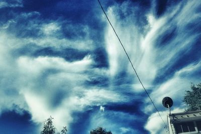 Low angle view of power lines against cloudy sky