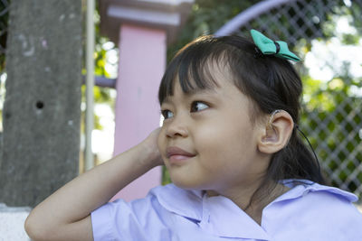 Close-up of cute girl looking away outdoors